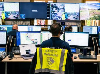 Säkerhetschef agerar dispatcher och övervakar fältteamet från flera datorskärmar.