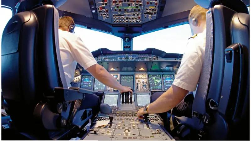Två piloter i ett flygplan med ptt bluetooth headset