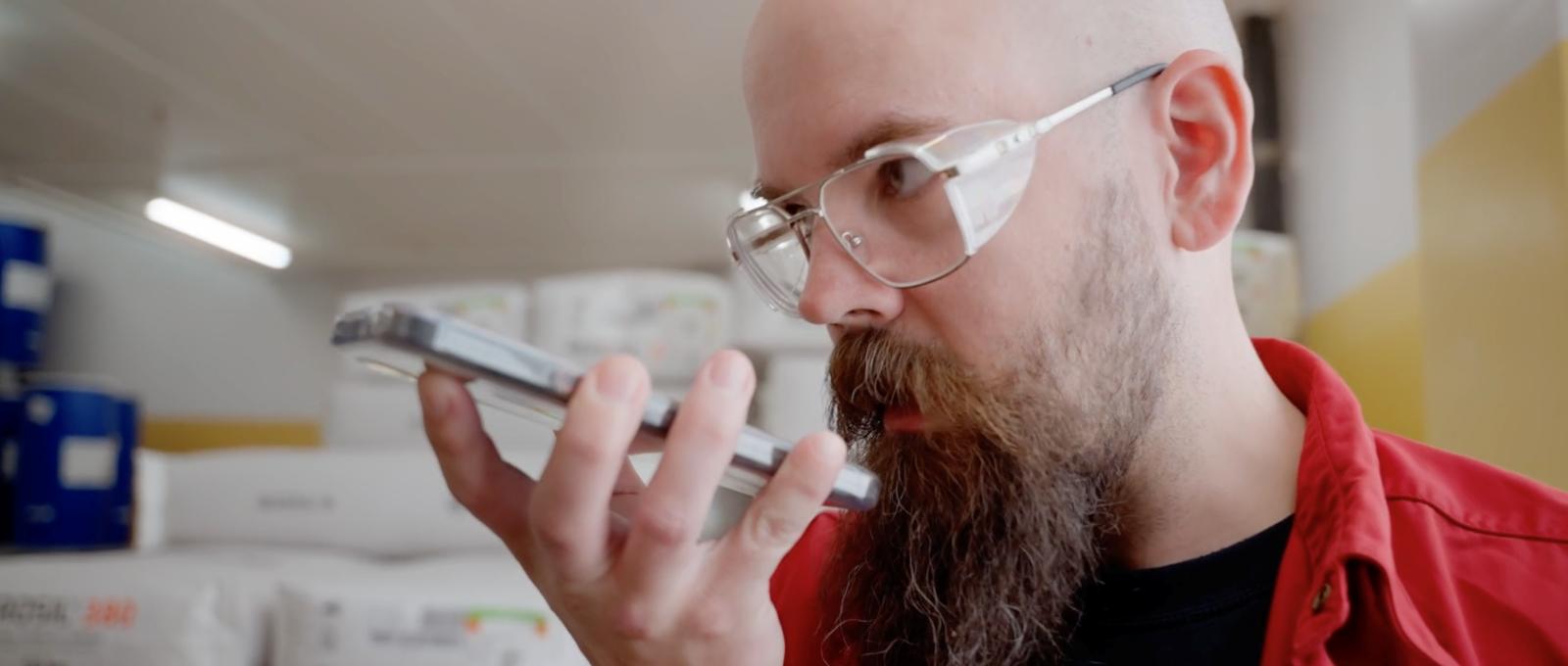 Läkemedelsarbetare som använder en push-to-talk-app på smartphone för intern kommunikation