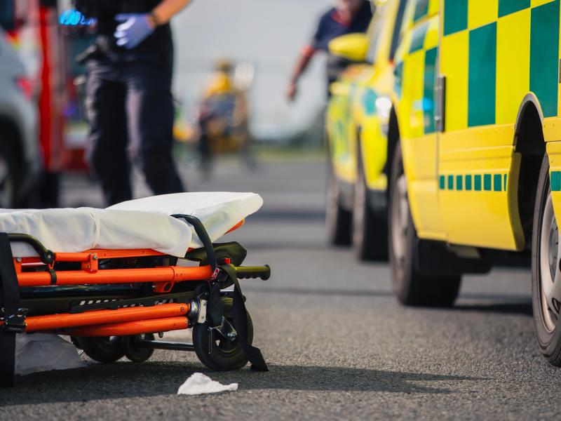 Ambulans med bår som ligger på marken