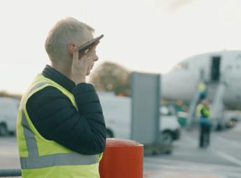 Flygplatsarbetare pratar i komradio-app från GroupTalk.