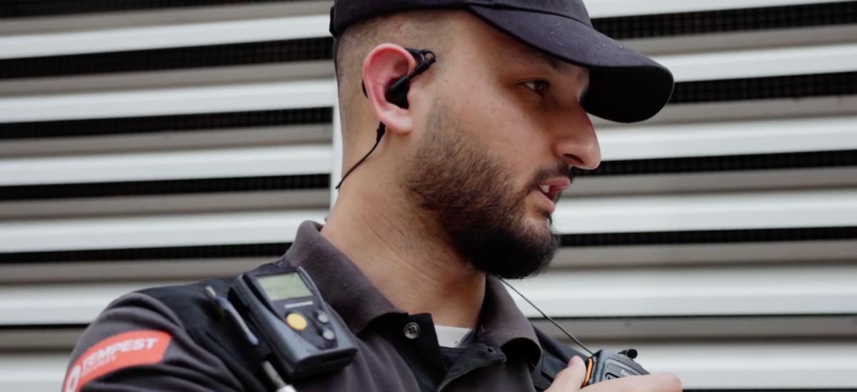 Väktare som använder monofon (RSM) och trådbundet headset för push to talk-kommunikation.