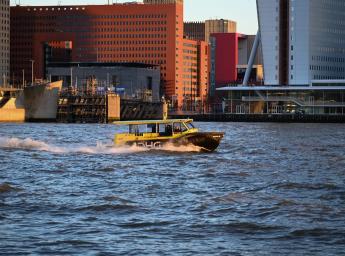 Taxibåt åker på vattnet i Rotterdam.