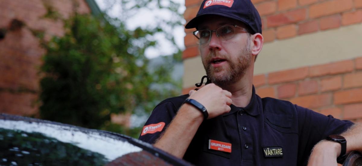 Tempest-väktare som använder push to talk-headset och komradio-app på smartphone.