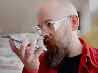 Läkemedelsarbetare pratar med arbetsteamet med hjälp av push to talk-app på iPhone.