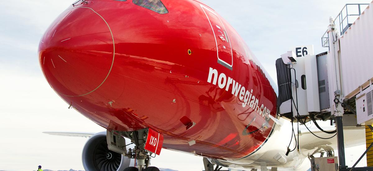 Norwegian Air Shuttle-flygplan som flyger i luften.