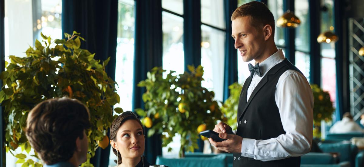 Servitör som serverar kunder på en restaurang.