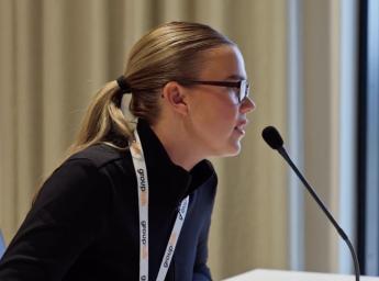 Kvinna pratar i bordsmikrofon på kommunikationscentralen