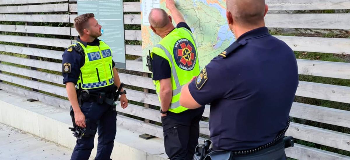 Poliser som pratar med varandra och tittar på en karta.