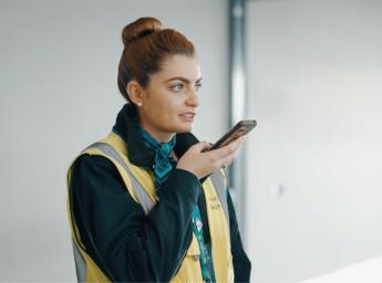 Flygplatsarbetare pratar med sina kollegor genom en walkie talkie app