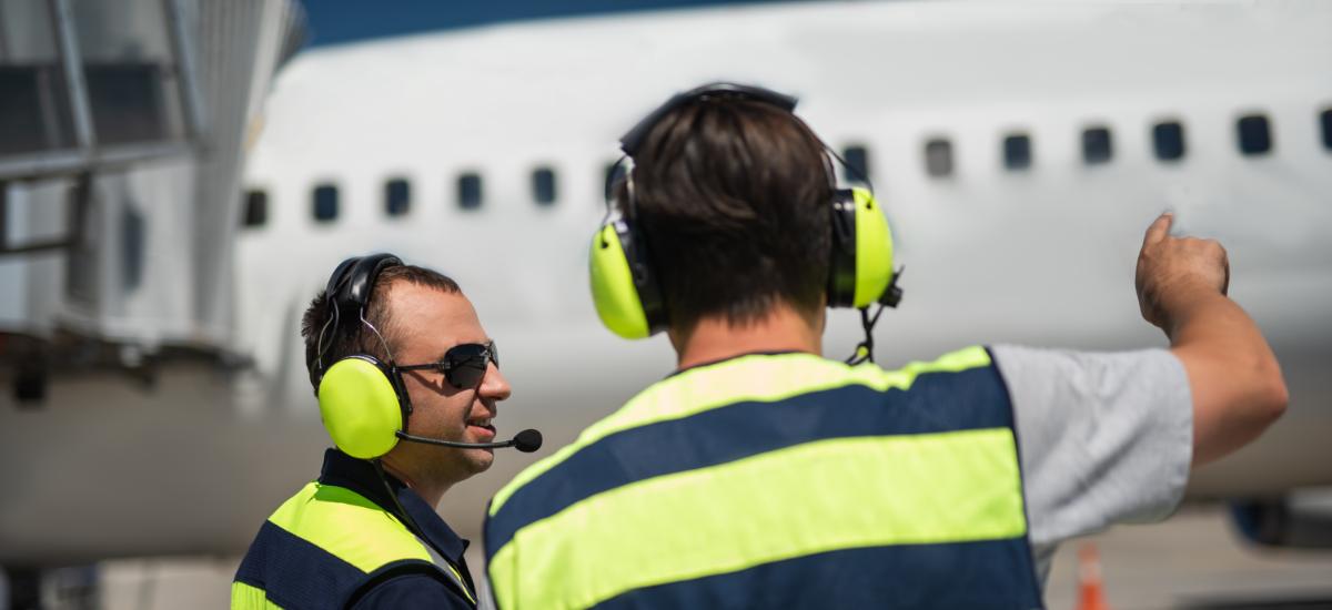 Flygplatsarbetare med Peltor PTT-headset vid gate.