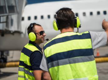 Flygplatsarbetare med Peltor PTT-headset vid gate.