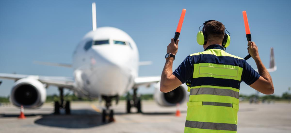 Flygplatsarbetare med Peltor PTT-headset vid gate.