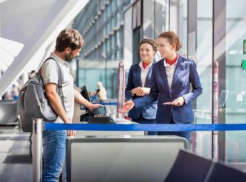 Passagerare får hjälp av flygplatspersonal vid ombordstigning på flygplan.