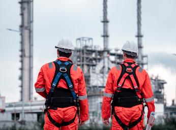 Oljeriggsarbetare bär ATEX-säkerhetsutrustning i farlig miljö.