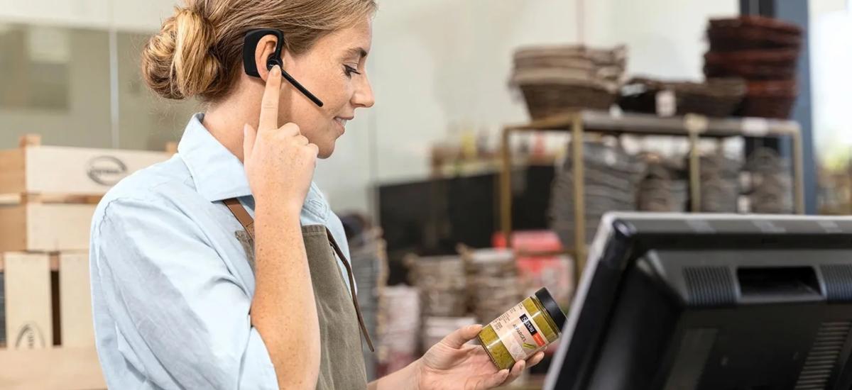 Butiksanställd använder Jabra Perform 45 push to talk-headset.