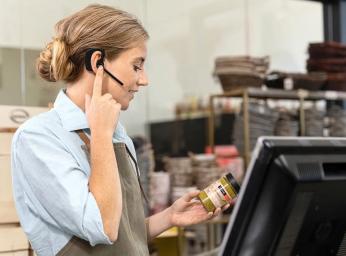 Butiksanställd använder Jabra Perform 45 push to talk-headset.