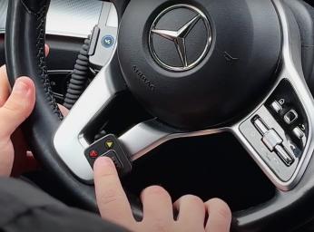 Taxichaufför använder push to talk-knapp i bilen för att prata med ledningscentralen