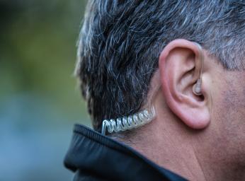 Väktare använder ett enbart lyssningsheadset med usb-c för push to talk-kommunikation.
