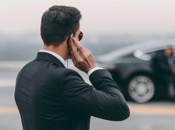 Civilklädd väktare använder push to talk-headset för att kommunicera med teamet.