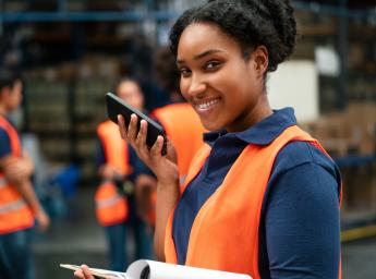 Logistikarbetare använder smartphone med 5G för push to talk.